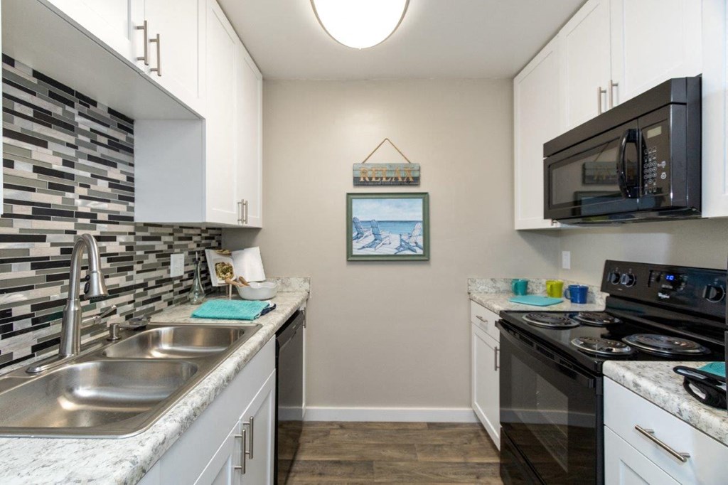a kitchen with a sink and a stove and a microwave