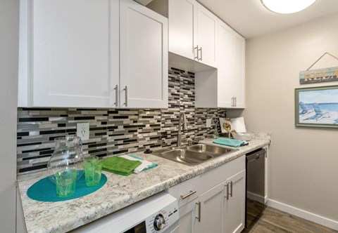 a kitchen with white cabinets and a sink