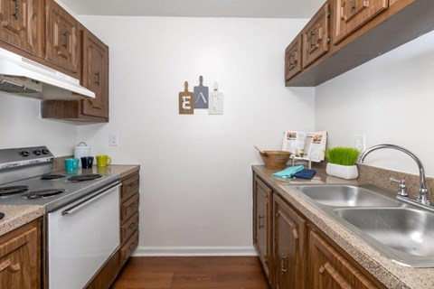 a kitchen with wooden cabinets and a sink and a stove