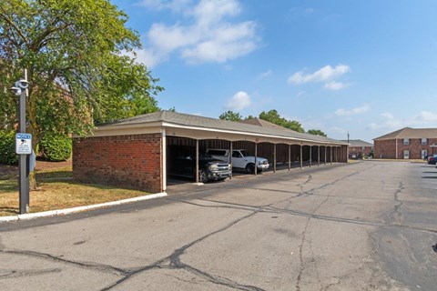 a parking lot with a brick building with cars parked in it