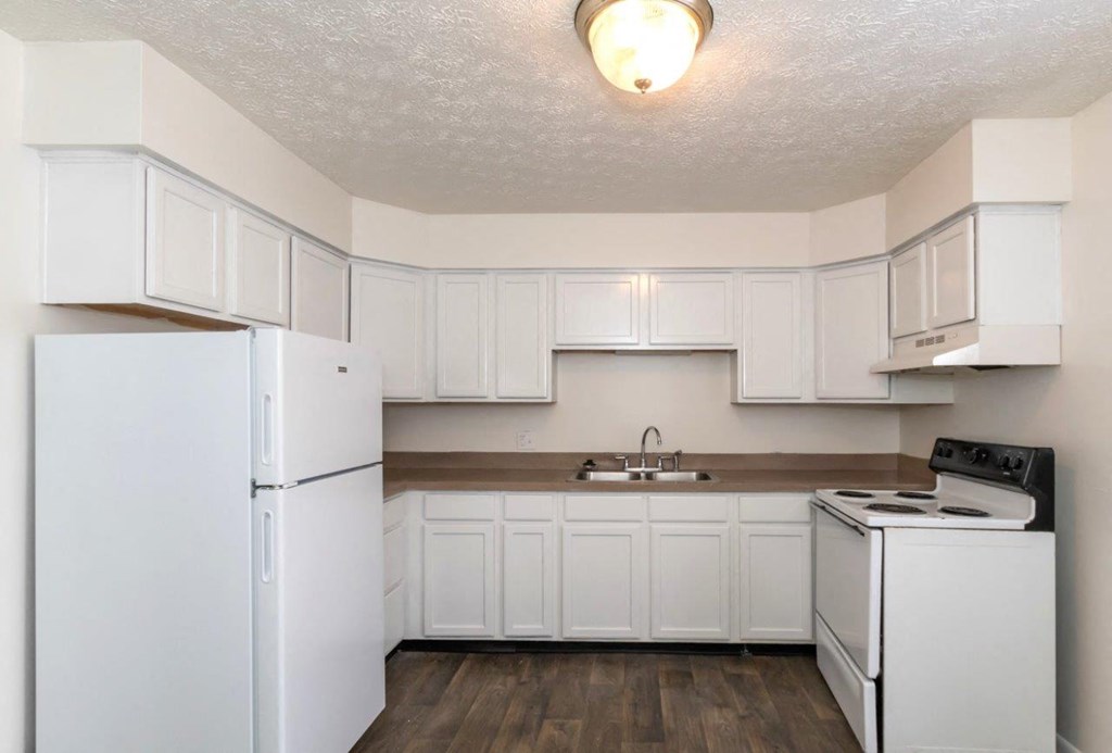 a white kitchen with white appliances and white cabinets