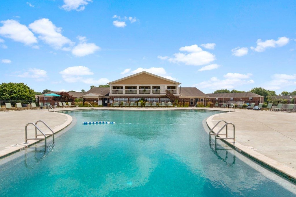 a large swimming pool with a house in the background