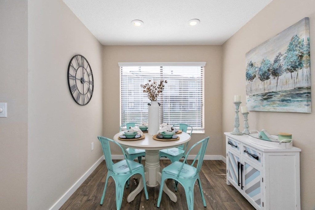 a dining room with a table and chairs and a large window