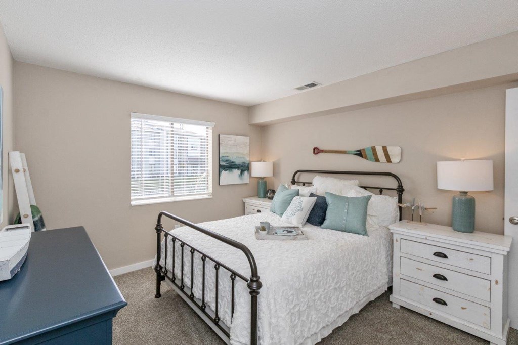 a bedroom with a bed and a dresser and a window