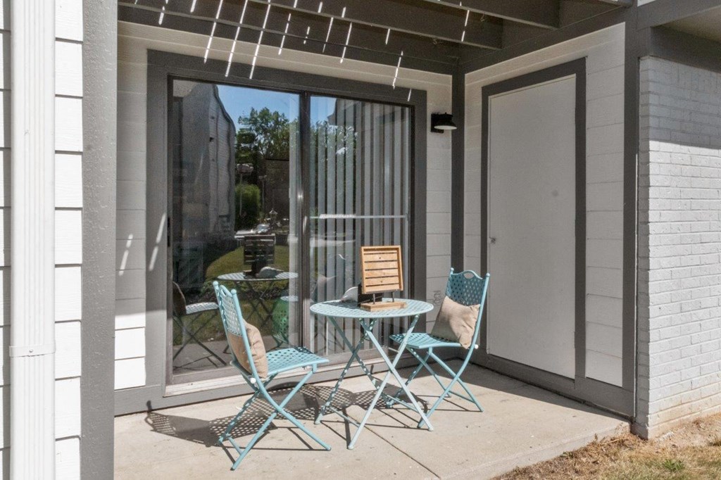 a patio with chairs and a table on a patio