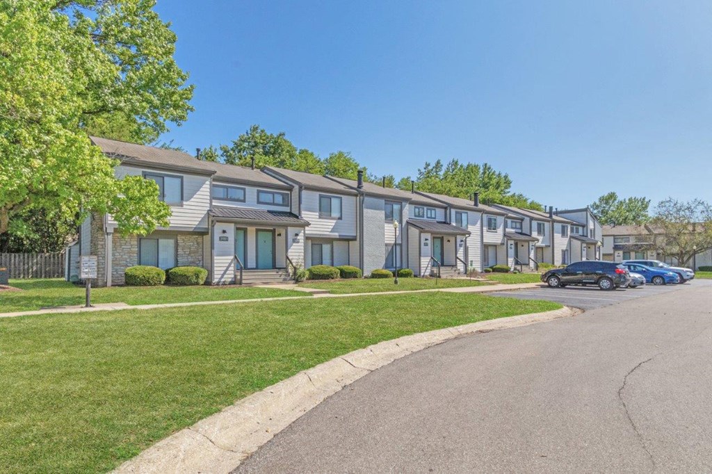 a row of houses with cars parked in front of them