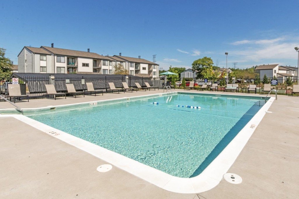 a swimming pool with a row of apartments in the background