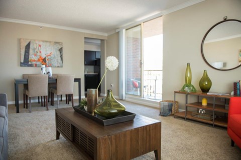 A living room with a brown coffee table and a painting on the wall.