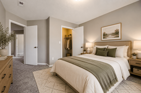 A bedroom with a large bed and a painting on the wall.