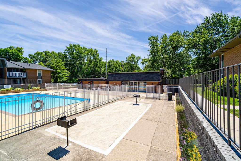 A pool surrounded by a fence with a sign in front of it.