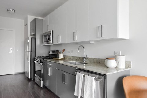 A modern kitchen with a stainless steel refrigerator and oven.