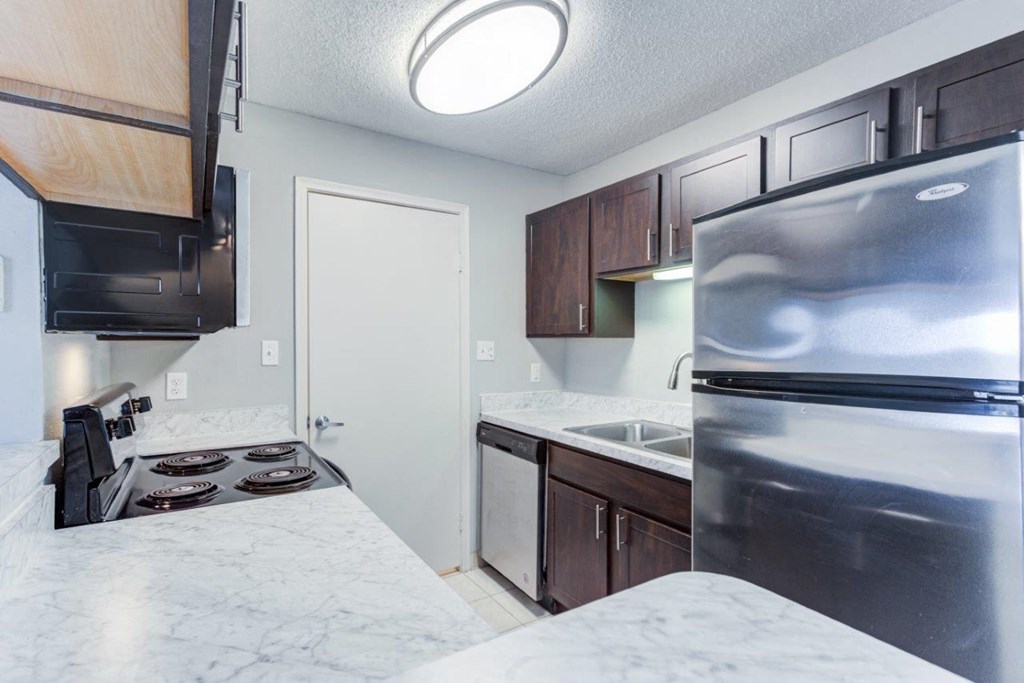 a kitchen with stainless steel appliances and marble counter tops