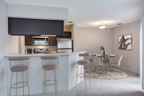 a kitchen with a bar and a dining table