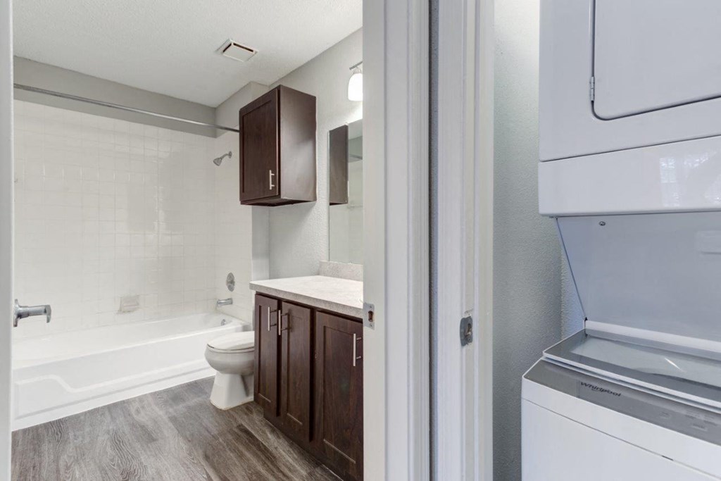 a bathroom with a washer and dryer and a toilet