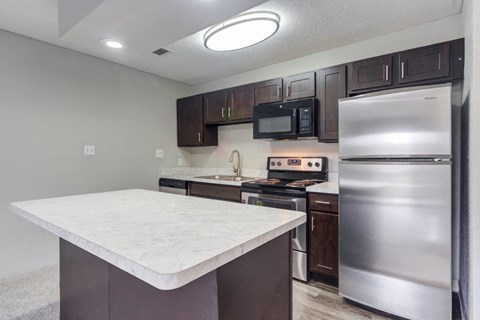 a kitchen with stainless steel appliances and a marble counter top