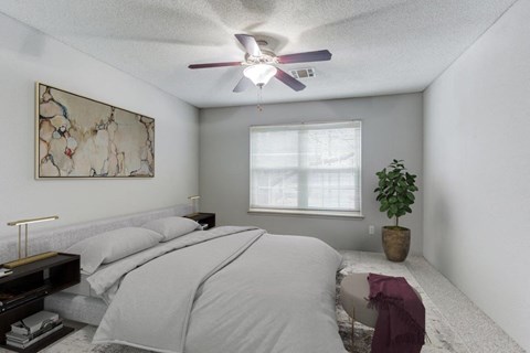 a bedroom with a bed and a ceiling fan