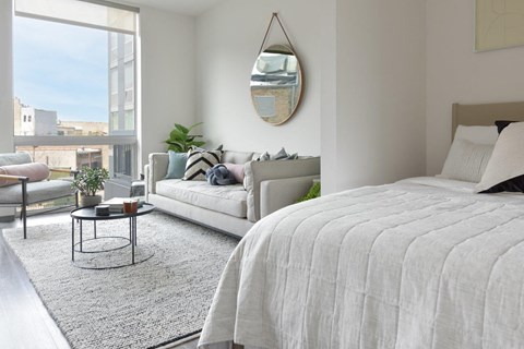 A bedroom with a large bed and a view of the city.