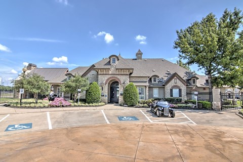 A large house with a parking lot in front.