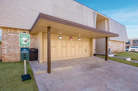 A sign in front of a building indicates that there is a pet park nearby.