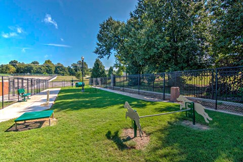 A park with a green bench and a playground.