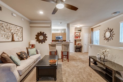 A living room with a couch, coffee table, and a ceiling fan.