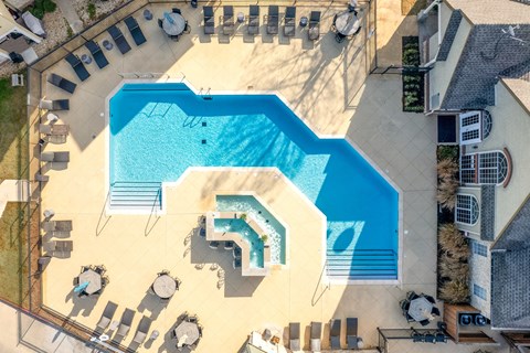 A large swimming pool with a slide and a hot tub.
