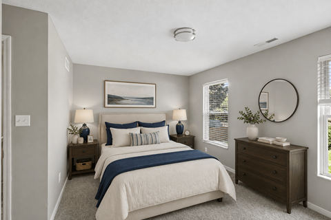 A bedroom with a large bed and a round mirror on the wall.