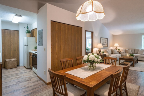 A dining room with a wooden table and chairs.