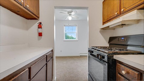 a kitchen with a stove and a ceiling fan