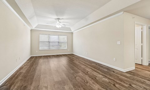 A room with wooden floors and a ceiling fan.