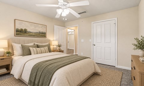 A bedroom with a large bed and a painting on the wall.