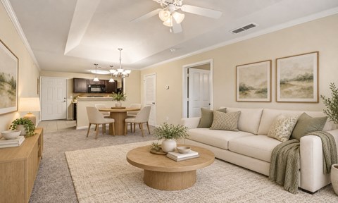 A living room with a white couch, a coffee table, and a dining table.