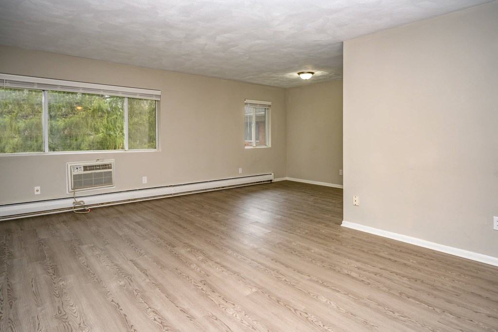 A room with a window and a wall-mounted air conditioner.