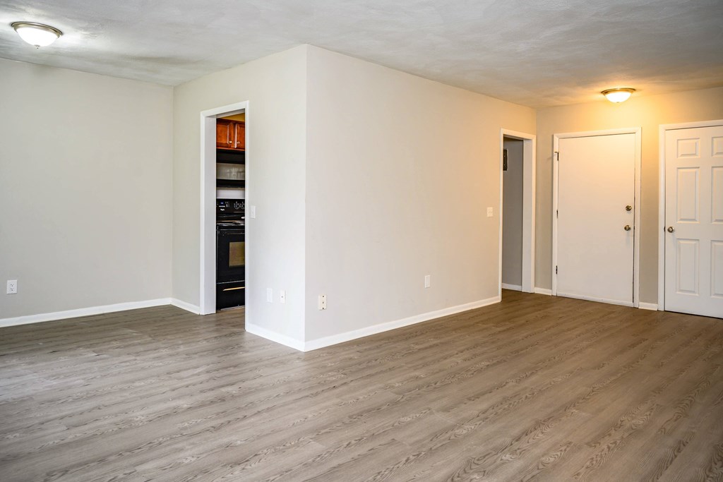 A room with a white wall and a wooden floor.