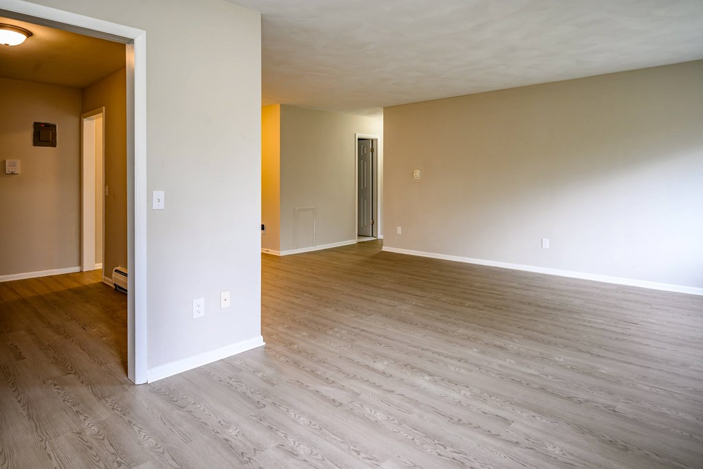 A room with light colored walls and a wooden floor.