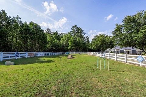 a fenced in backyard with a grass field and a swing set