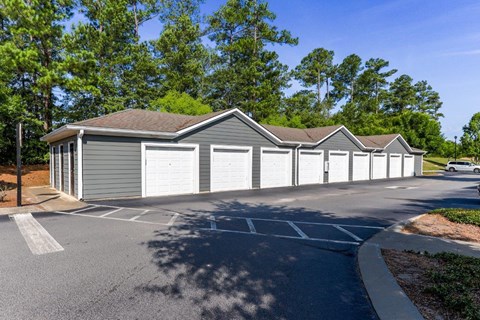 a row of garages in a parking lot with trees