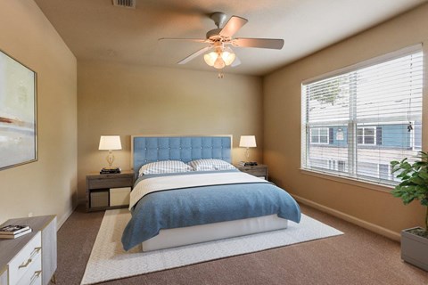 a bedroom with a bed and a ceiling fan