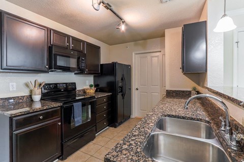 a kitchen with black appliances and granite counter tops