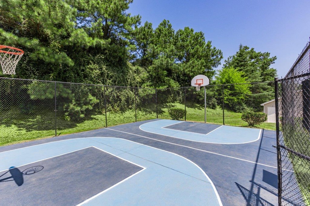 a basketball court with a basketball hoop and a fence