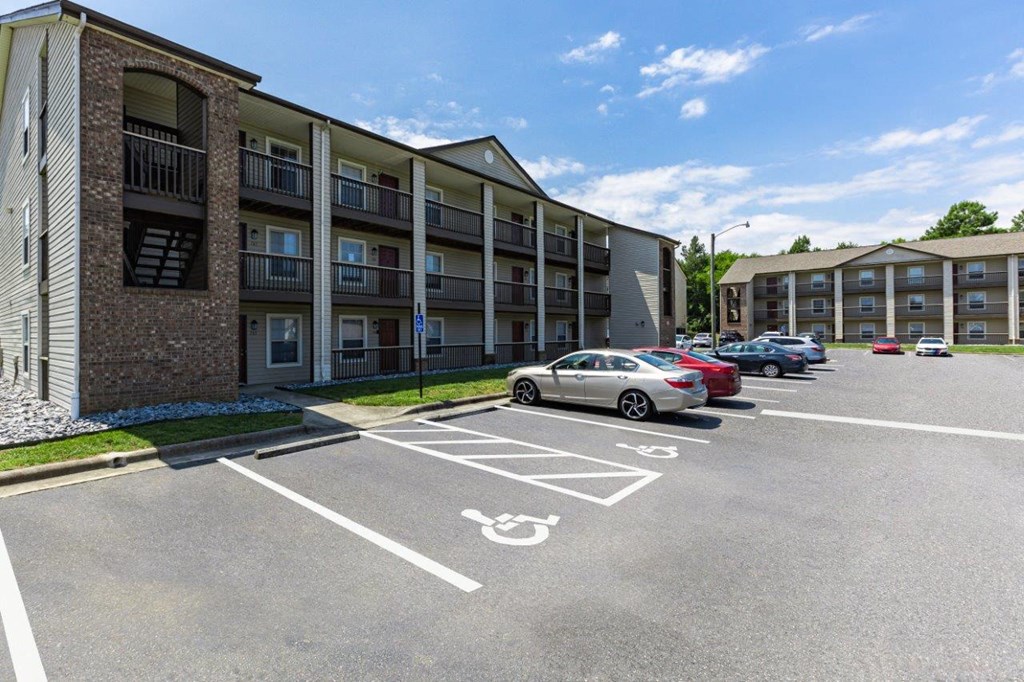 a parking lot with cars in front of an apartment building