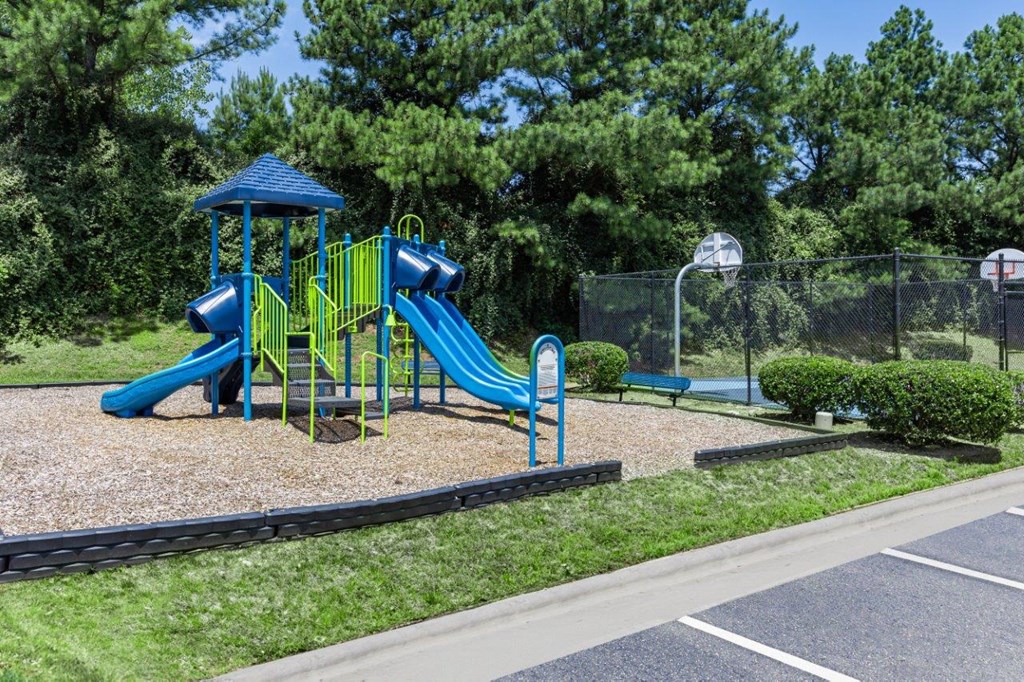 a playground with a blue and yellow slide in a park