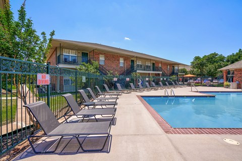 A pool area with chairs and a sign that says "NO PETS".