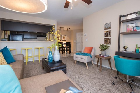 A living room with a blue chair and a grey couch.
