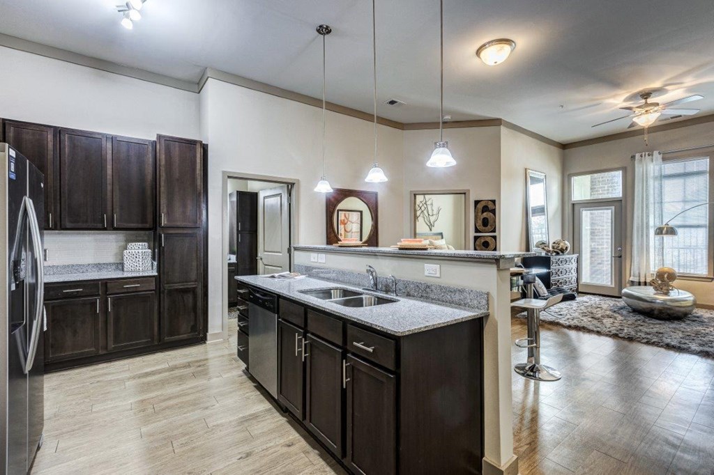 A modern kitchen with dark wood cabinets and a large island.