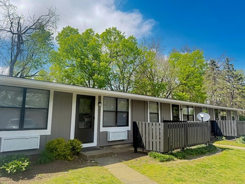 A row of houses with green trees in the background.