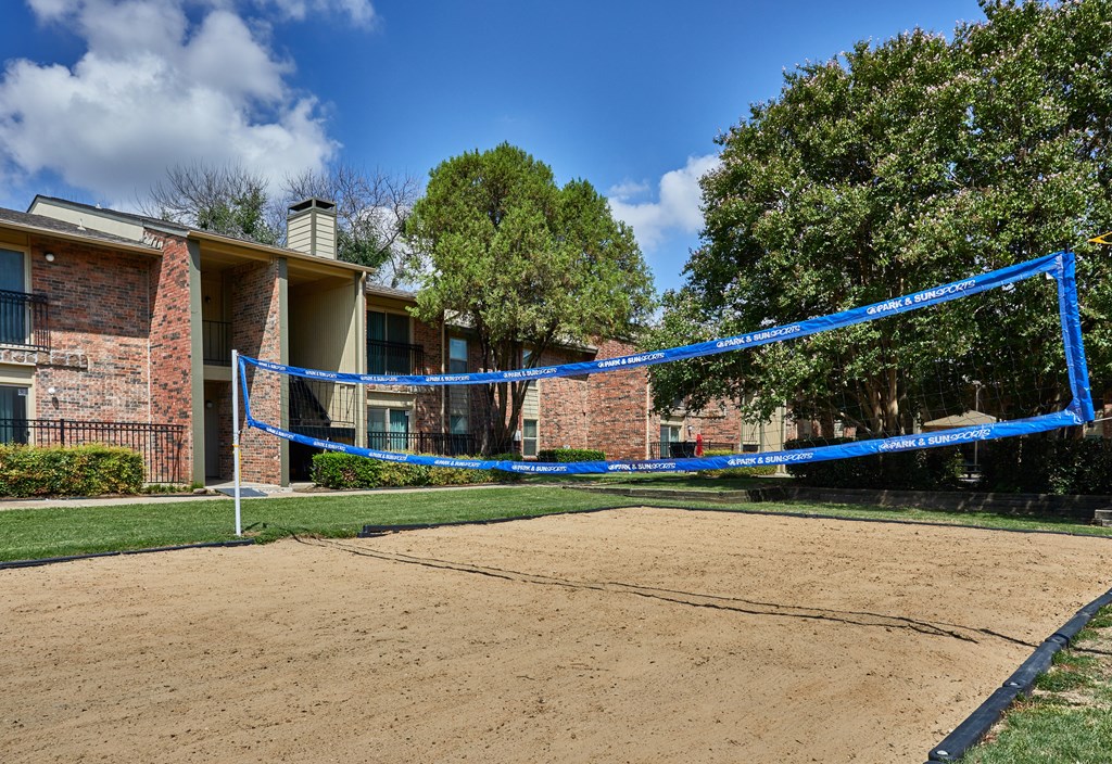 A volleyball court is set up in front of a brick building.