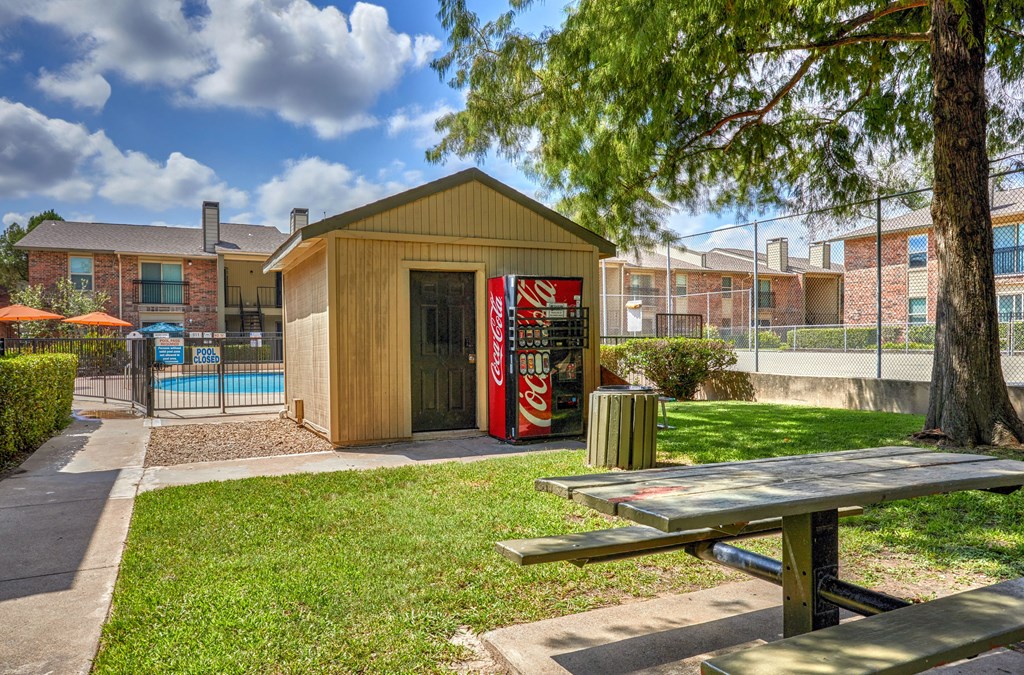 A wooden building with a Coca Cola machine in front of it.