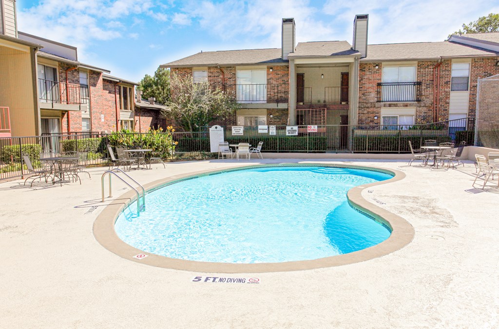 A small pool in a courtyard surrounded by buildings.