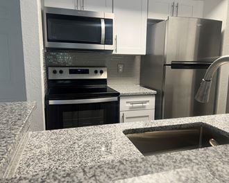 a kitchen with granite countertops and stainless steel appliances